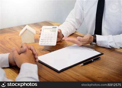 Real estate agent showing the purchase price on a calculator to customer