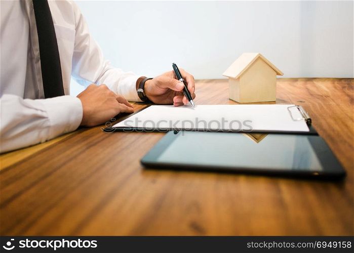 Real Estate agent with contract signature and analyzing valuation of house property
