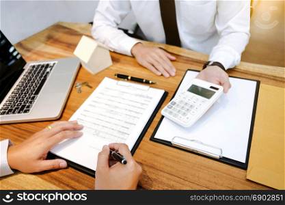 Real Estate agent with customer making contract signature and analyzing valuation