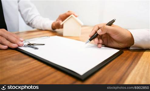 Real Estate agent with customer making contract signature buy / rent a house