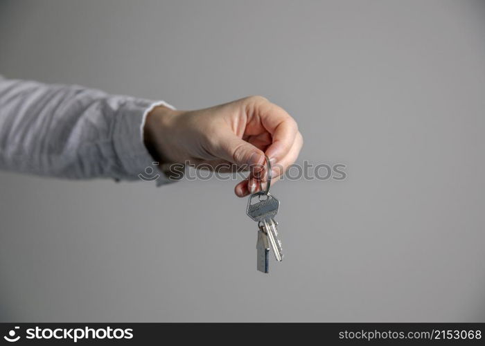 Real estate agent with house model and keys, selling house,property owner mortgage concept with copy space on gray background space for text. Real estate agent with house model and keys, selling house,property owner mortgage concept with copy space on gray background