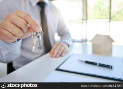 real estate agent with key and house model