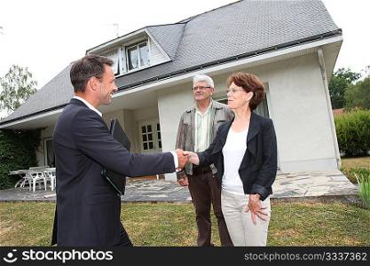 Real-estate agent with senior couple buying new house