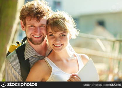 Real estate and family concept - young couple looking at blueprint project building plans dreaming about new house in modern residential area, construction site in the background. couple with blueprint project outdoor