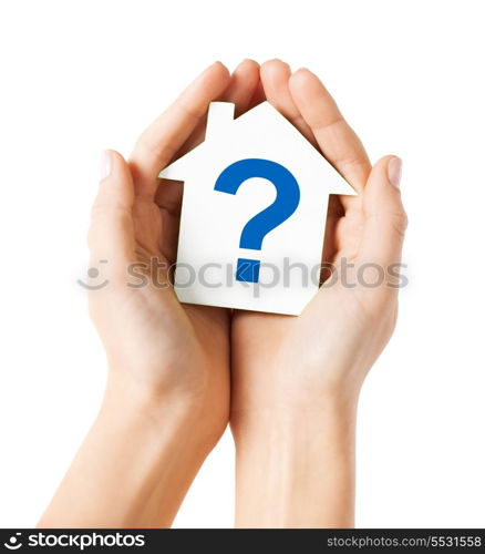 real estate and family home concept - hands holding paper house with question mark