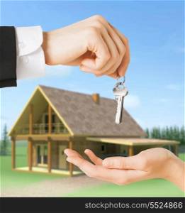 real estate and home concept - close up of man hand passing house keys to woman