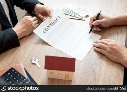 Real Estate broker or sale agent giving consultation to customer about buying house sign agreement document contract. Home loan