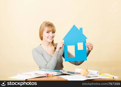 Real estate building construction concept. Young happy blonde woman holding paper model of house. Female buyer with new flat apartment.. Happy woman holding house model.