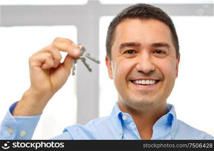 real estate business, housing and people concept - happy smiling man holding keys. happy smiling man holding keys