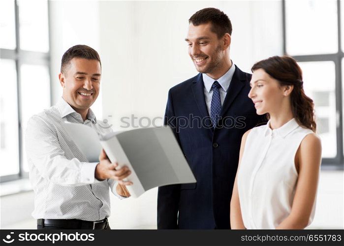 real estate business, sale and people concept - happy smiling realtor with folder showing documents to customers at new office room. realtor with folder showing documents to customers. realtor with folder showing documents to customers