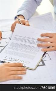 real estate business, sale and people concept - male realtor&rsquo;s hands and customers signing property purchase contract at office. customer signing contract document at office
