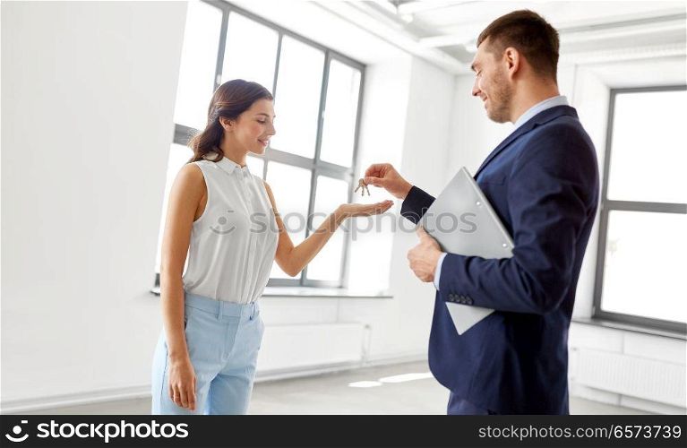 real estate business, sale and people concept - realtor giving key to customer or new office owner. realtor giving key to customer at new office