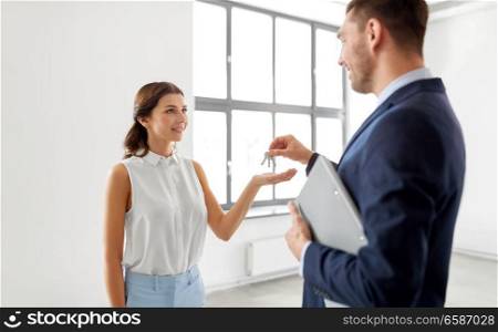 real estate business, sale and people concept - realtor giving key to customer or new office owner. realtor giving key to customer at new office