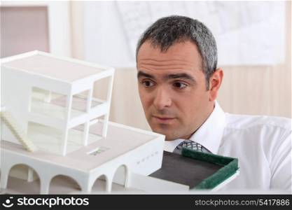 real estate businessman holding an architectural model