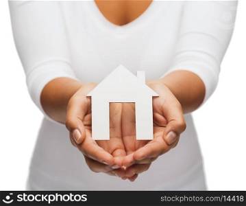 real estate concept - closeup of woman hands holding paper house