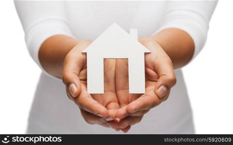 real estate concept - closeup of woman hands holding paper house. woman hands with paper house