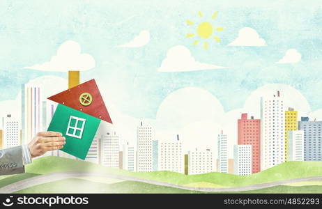 Real estate concept. Hand of business person holding house card