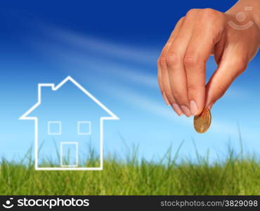 Real estate concept. Hand with coin and house.