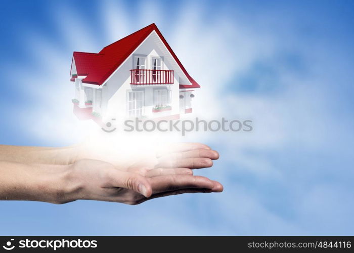 Real estate concept. Human hands holding model of dream house