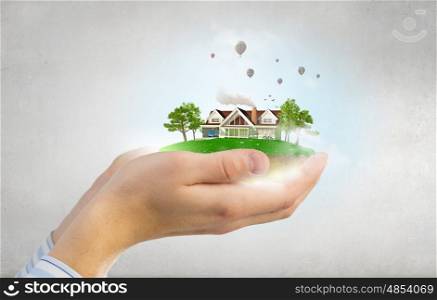 Real estate concept. Human hands holding model of dream house
