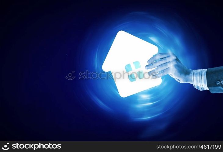 Real estate concept. Human hands holding model of house on blue background