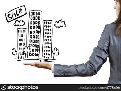Real estate concept. Rear view of businesswoman holding sketch of building in palm