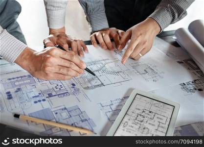 Real-estate concept, Two engineer and architect discussing blueprints data working and digital tablet on construction building project.