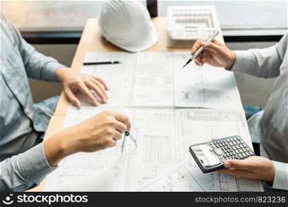 Real-estate concept, Two engineer and architect discussing blueprints data working and digital tablet on construction building project