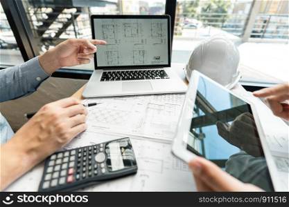 Real-estate concept, Two engineer and architect discussing blueprints data working and digital tablet on construction building project