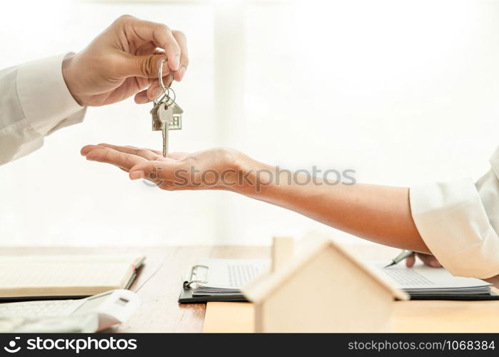 Real Estate developer Agent and sign on document giving keys of new house, Property agent giving offer to buyer