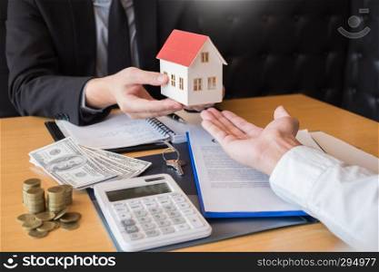 Real Estate developer Agent and sign on document giving keys of new house, Property agent giving offer to buyer 