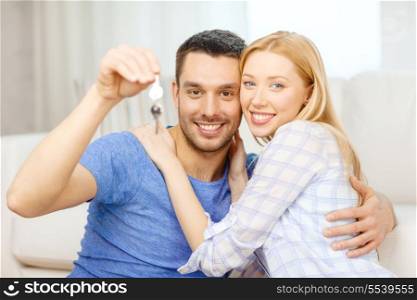 real estate, family and couple concept - smiling couple holding keys at home