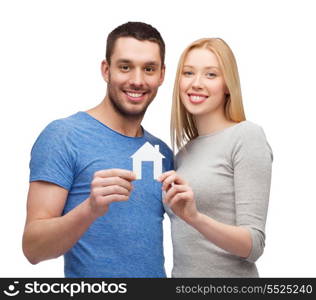 real estate, family and couple concept - smiling couple holding white paper house