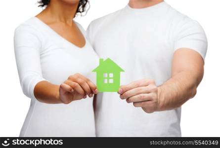 real estate, family and eco concept - closeup picture of couple hands holding green house