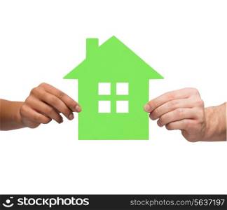 real estate, family and eco concept - closeup picture of multiracial couple hands holding green house