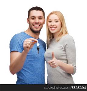 real estate, family, gesture and couple concept - smiling couple holding keys and showing thumbs up