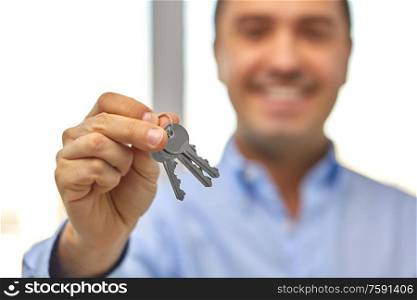 real estate, housing and people concept - close up of smiling man holding house keys. close up of smiling man holding house keys