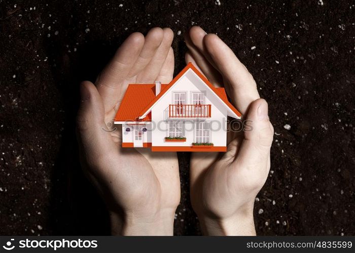 Real estate investment. Hands holding house representing home ownership and real estate concept