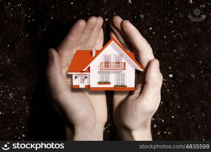 Real estate investment. Hands holding house representing home ownership and real estate concept