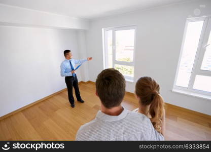 real estate, mortgage and people concept - happy smiling realtor with clipboard and couple at new home. realtor with clipboard and couple at new home