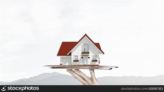 Real estate offer. Hand of waiter offering house model on tray