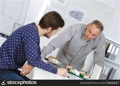 real estate professor with student and scale model