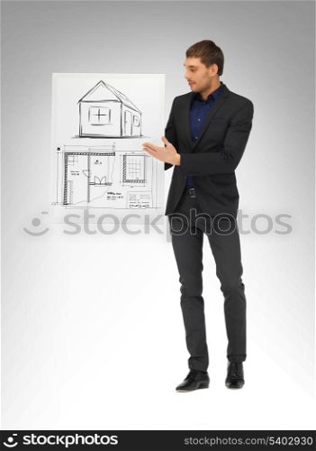 real estate, property, business and accomodation concept - man holding picture with house and blueprint