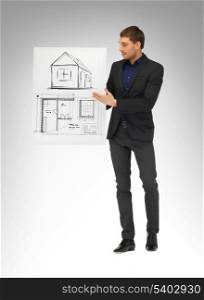 real estate, property, business and accomodation concept - man holding picture with house and blueprint