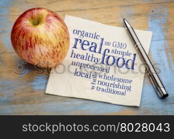 real food word cloud on a napkin with a fresh apple - healthy lifestyle concept