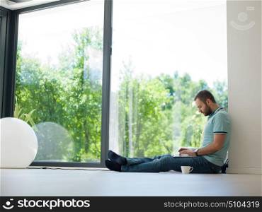 Real man Using laptop on the floor At Home Drinking Coffee Enjoying Relaxing