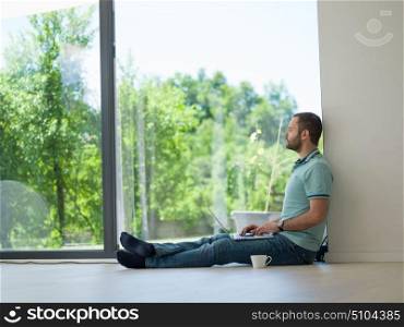 Real man Using laptop on the floor At Home Drinking Coffee Enjoying Relaxing
