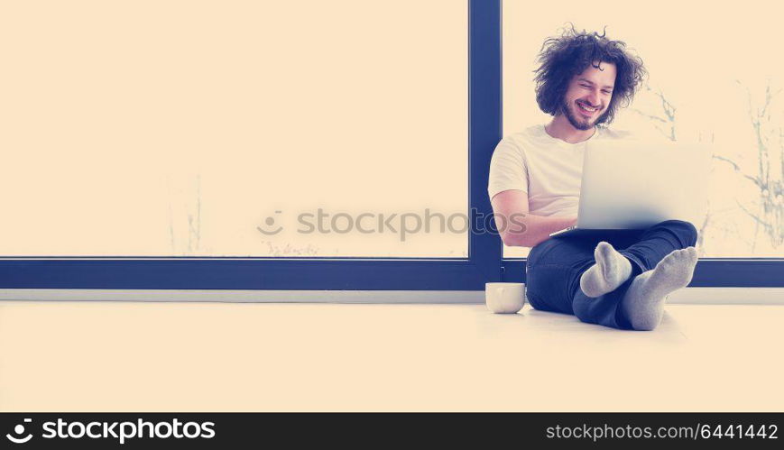 Real man Using laptop on the floor At Home Enjoying Relaxing