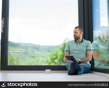 Real man Using tablet on the floor At Home Drinking Coffee Enjoying Relaxing