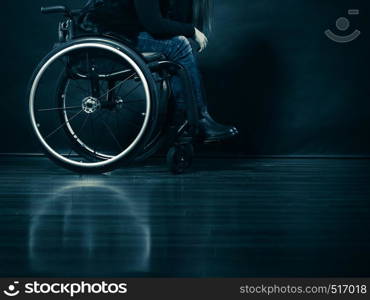 Real people, disability and handicap concept. Young woman invalid girl sitting on wheelchair part of body studio shot on black. Woman invalid girl sitting on wheelchair